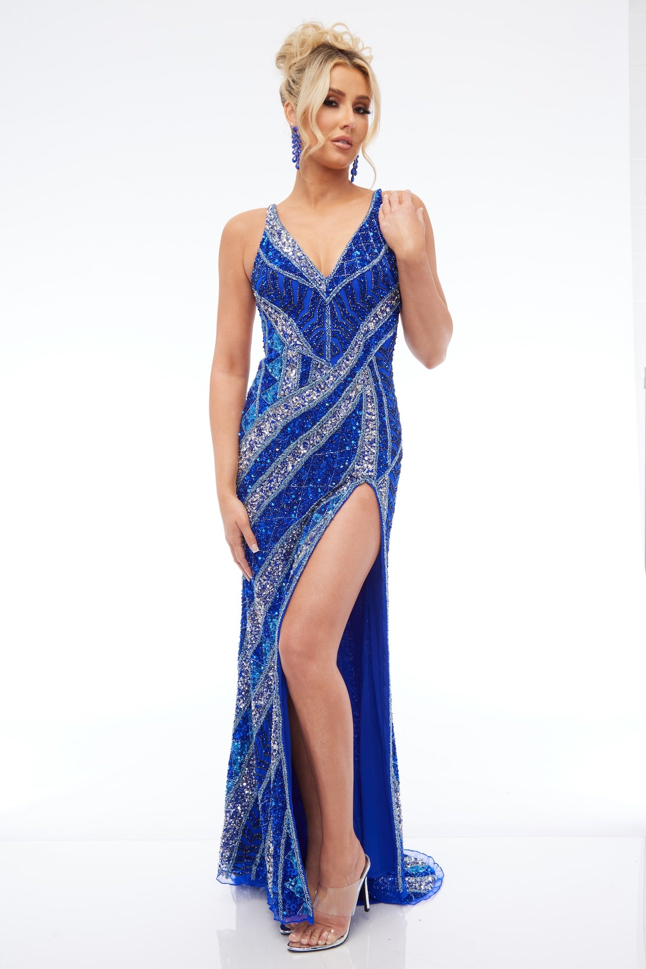 Front view of Style 7679: a beaded royal blue prom dress featuring a high slit, open strappy back, and spaghetti straps.