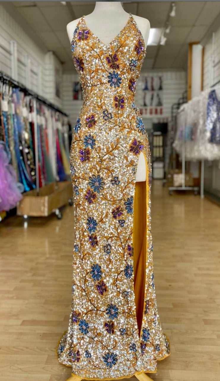 Front view of Style 7703: a dazzling beaded gold prom dress featuring a high slit, open back, and spaghetti straps.