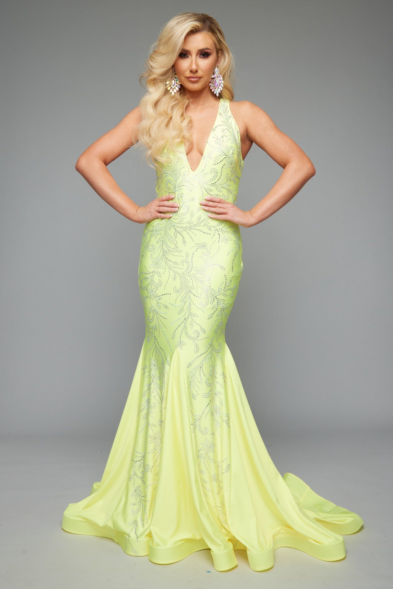 Front view of stunning yellow best selling fitted prom dress with a plunge neckline, open back, halter neckline, and applique design.