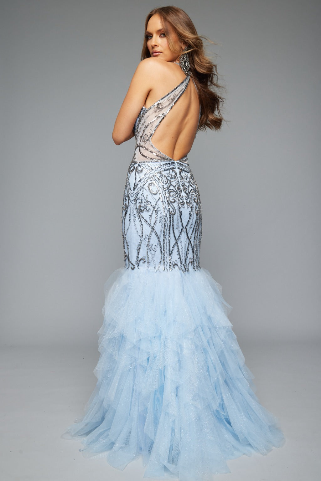 Back view of Jasz Couture Style 7629: a captivating prom dress featuring a beaded applique design, halter neckline, open back, and tulle skirt. Shown in light blue and a must-have for prom night.