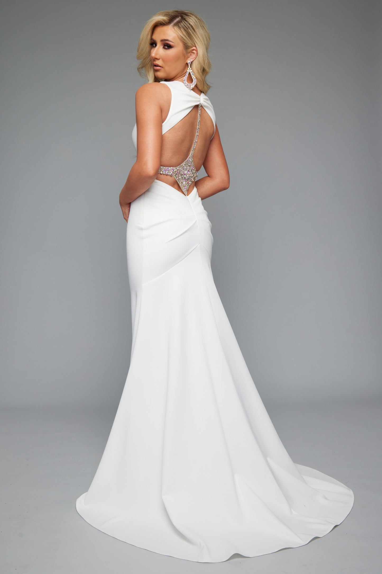 Back view of style 7644: an elegant fitted white prom dress with beaded accents, an open back, and cutout plunge neckline.