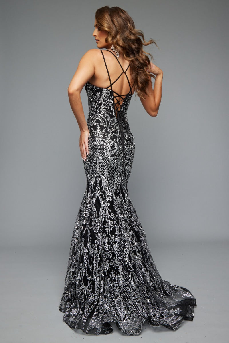 Back view of Style 7648: an eye-catching, best selling black and silver prom dress featuring an applique design, corset lace up detail, and spaghetti straps.