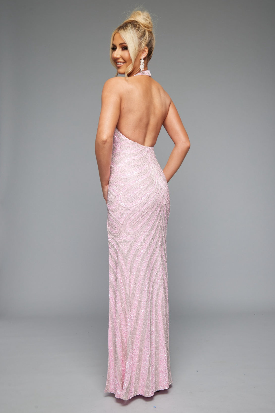 Back view of Jasz Couture Style 7651: a dazzling pink beaded prom dress with a high slit, halter top, and open back.