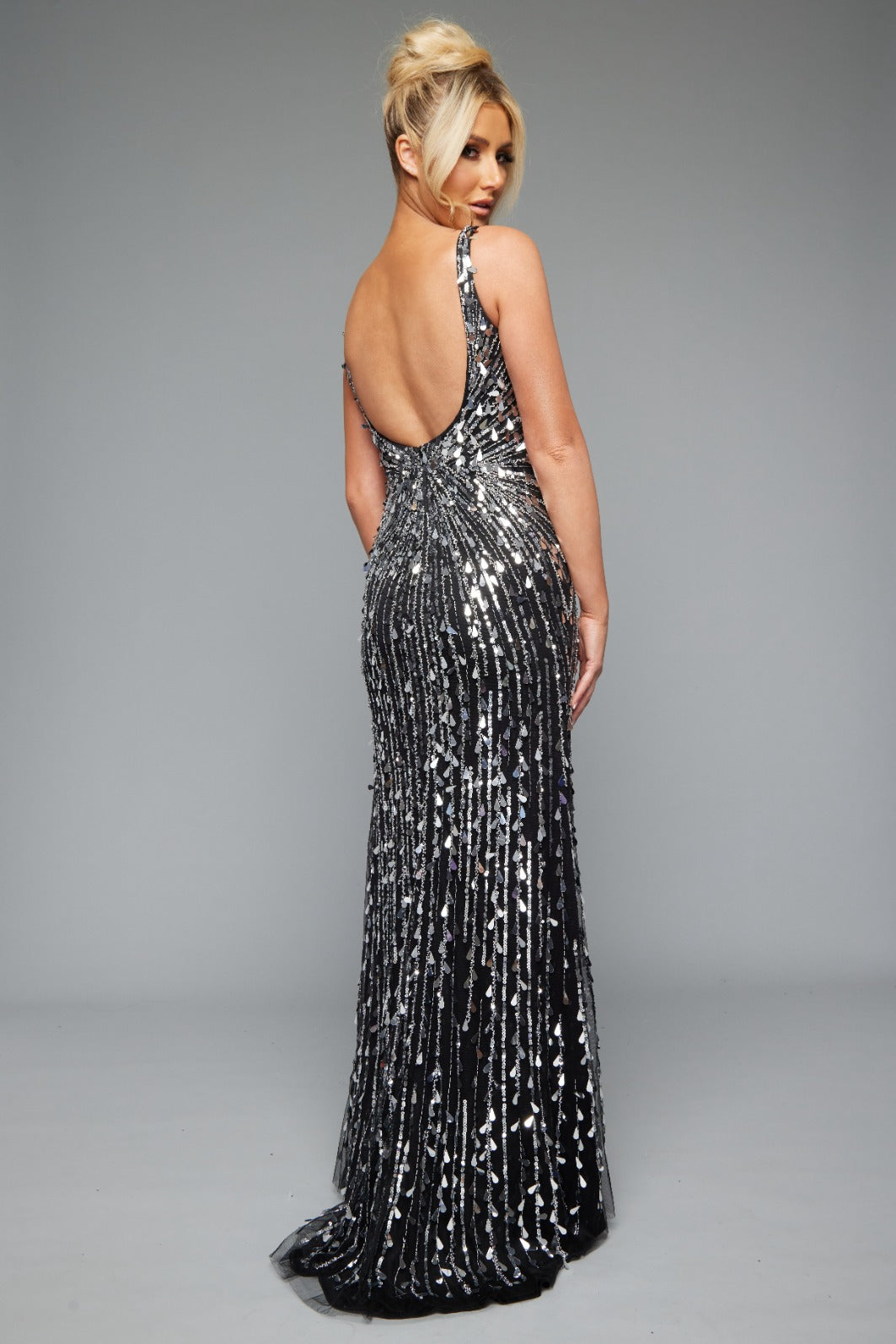 Back of Jasz Couture Style 7668: a sparkling black and silver prom dress with beads, a high slit, an open back, and V neckline.