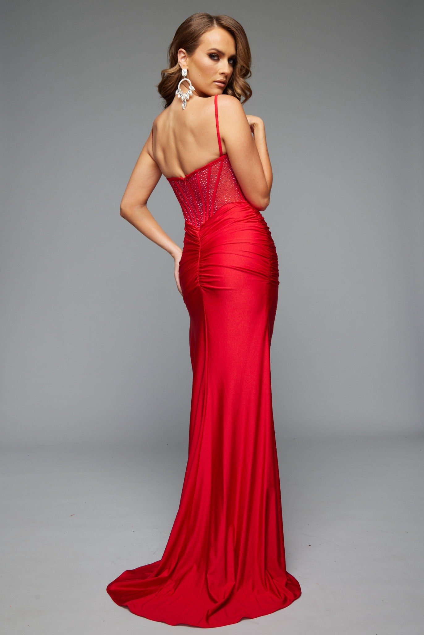 Back view of best selling Jasz Couture Style 7682: an elegant spaghetti strap prom dress with a high slit and corset details. Shown in red.