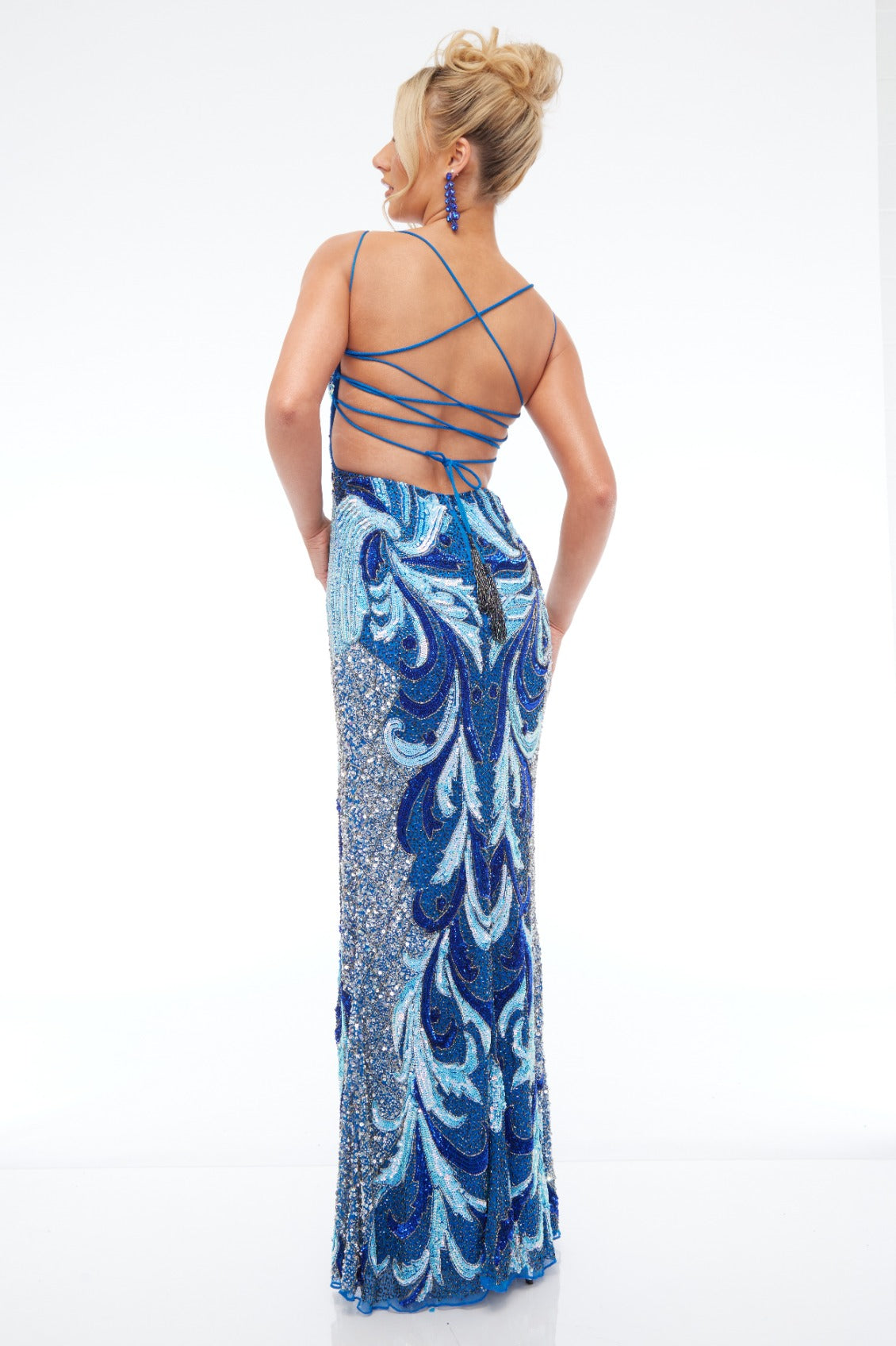 Back view of Style 7688: a bold beaded royal blue prom dress featuring a high slit and lace up back.