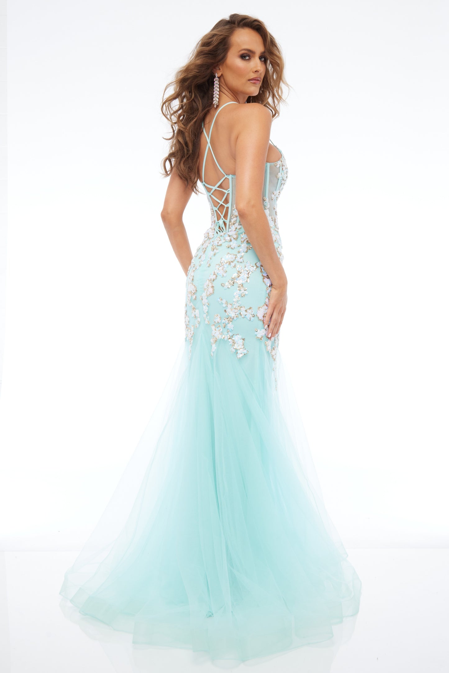 Back view of Style 7700: a chic mint prom dress featuring applique details, corset lace up back, spaghetti straps, and tulle skirt.