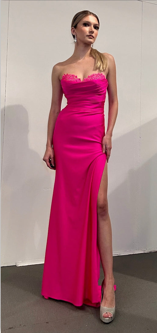 Front view of Style 7711: a captivating strapless hot pink prom dress featuring a corset, a high slit, and a sweetheart neckline.