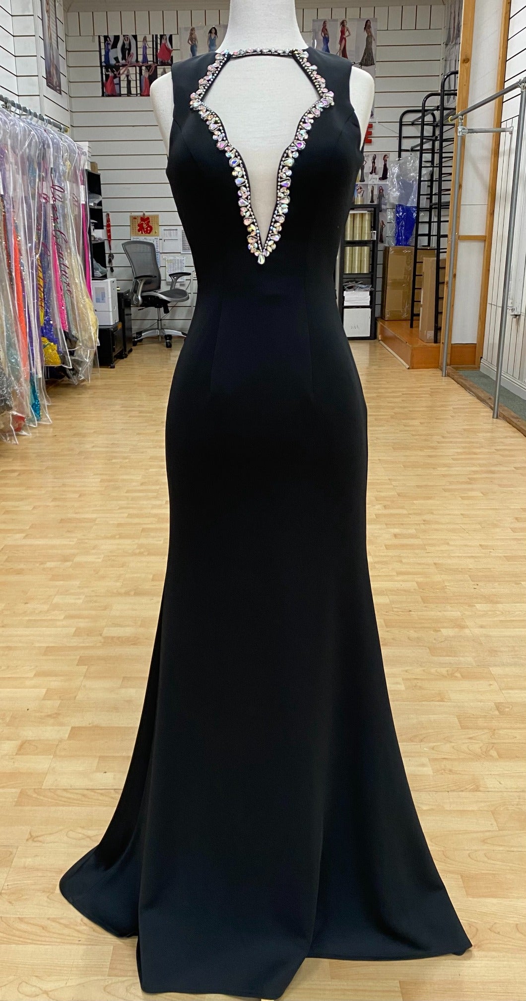 Style 7644: an elegant fitted black prom dress with beaded accents, an open back, and cutout plunge neckline.
