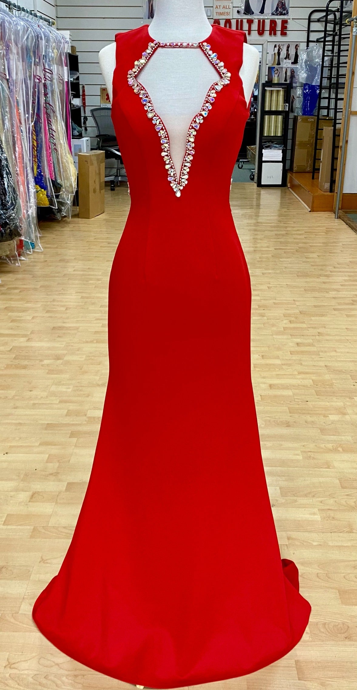 Style 7644: an elegant fitted red prom dress with beaded accents, an open back, and cutout plunge neckline.