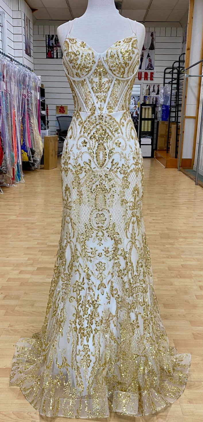 Front view of Style 7648: an eye-catching, best selling white and gold prom dress featuring an applique design, corset lace up detail, and spaghetti straps.