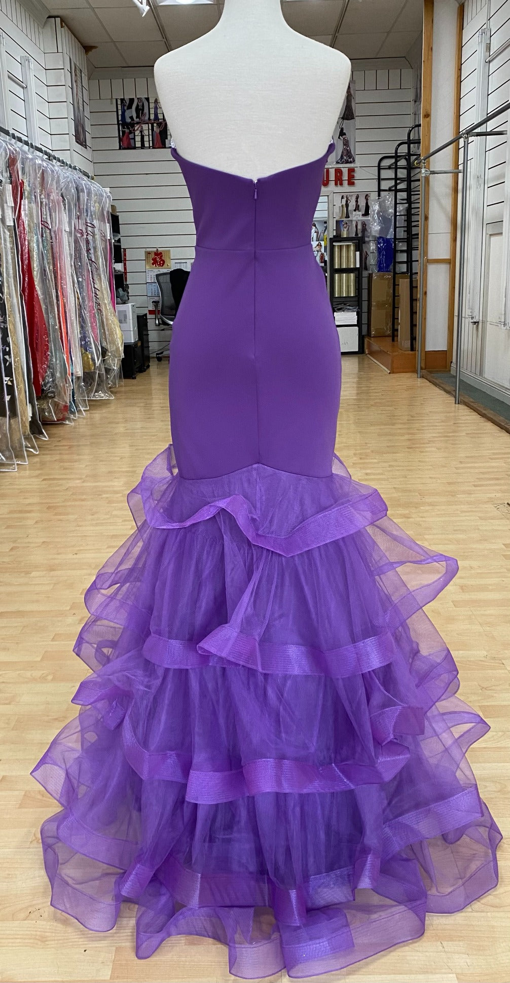 Back of Style 7670: a captivating fitted purple prom dress with a strapless plunge neckline and tulle skirt.