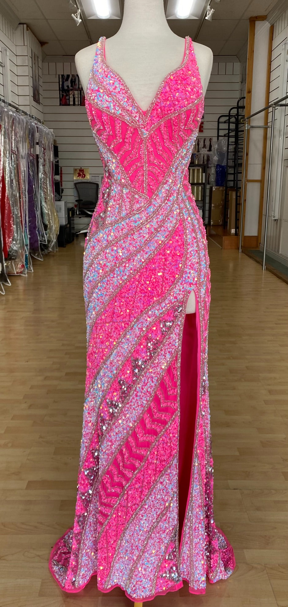 Front view of Style 7679: a beaded hot pink prom dress featuring a high slit, open strappy back, and spaghetti straps.