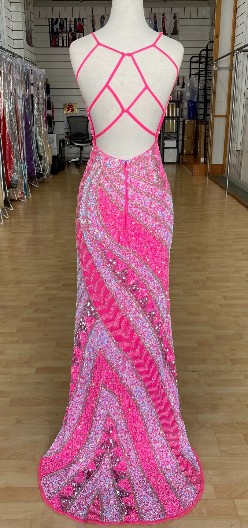 Back view of Style 7679: a beaded hot pink prom dress featuring a high slit, open strappy back, and spaghetti straps.