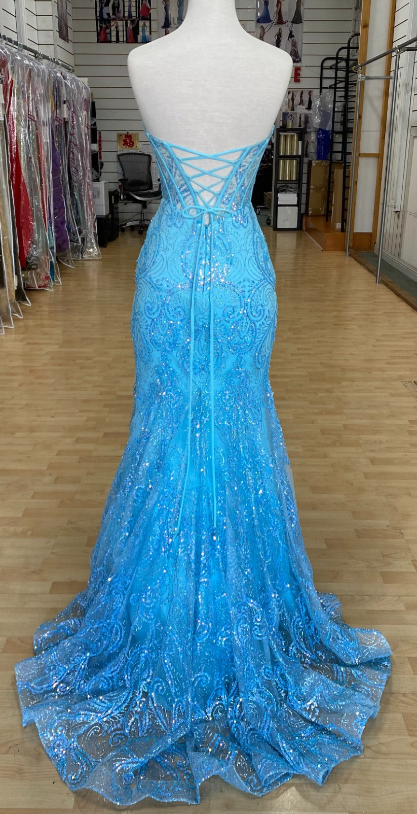 Back view of Style 7707: a bold strapless light blue prom dress featuring a sweetheart neckline and a corset lace up back.