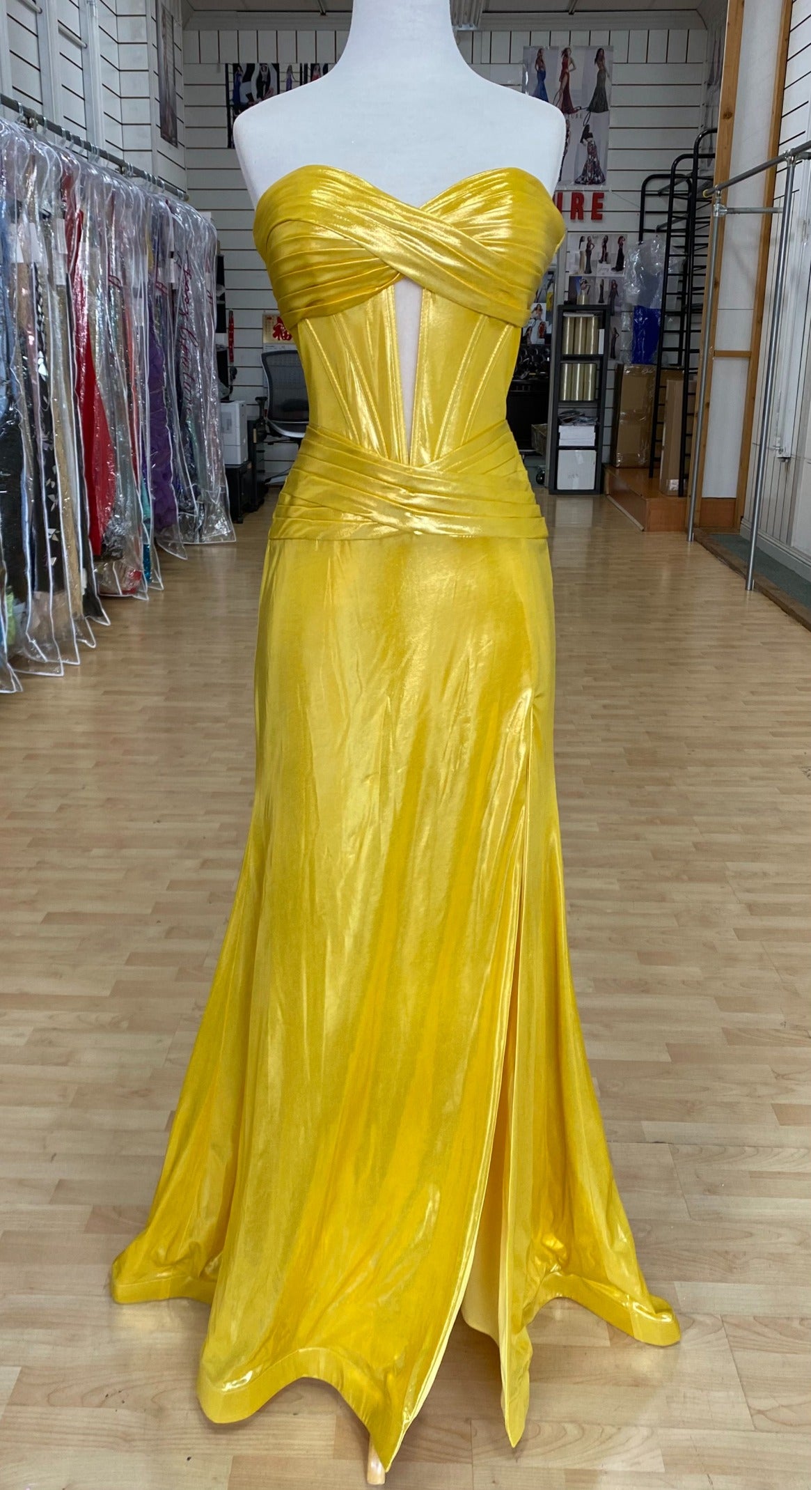 Front view of best selling Style 7705: a strapless prom dress featuring cutouts, a fitted design, a high slit, and a sweetheart neckline. Shown in yellow.