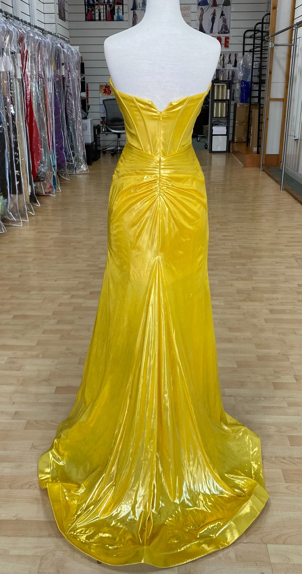 Back view of best selling Style 7705: a strapless prom dress featuring cutouts, a fitted design, a high slit, and a sweetheart neckline. Shown in yellow.