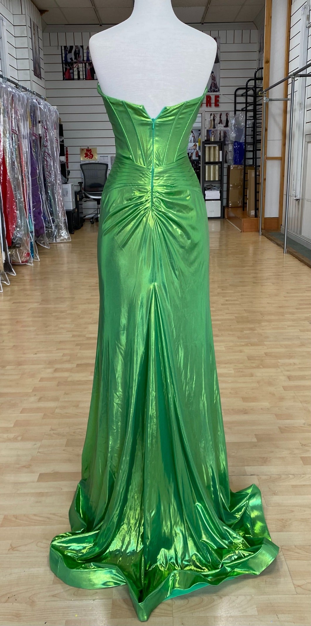 Back view of best selling Style 7705: a strapless prom dress featuring cutouts, a fitted design, a high slit, and a sweetheart neckline. Shown in green.