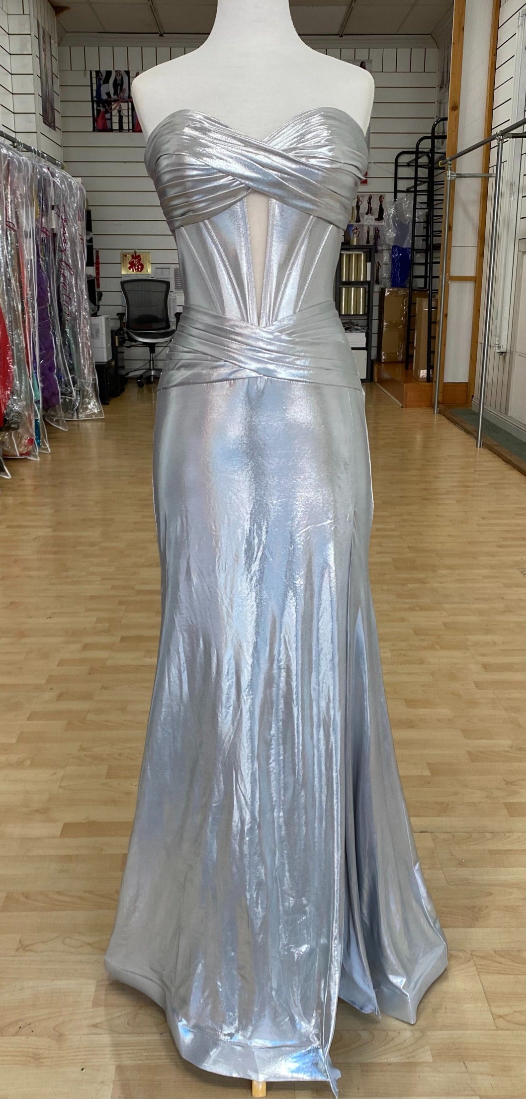 Front view of best selling Style 7705: a strapless prom dress featuring cutouts, a fitted design, a high slit, and a sweetheart neckline. Shown in silver.