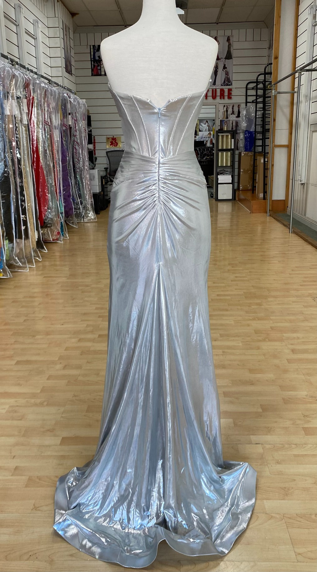 Back view of best selling Style 7705: a strapless prom dress featuring cutouts, a fitted design, a high slit, and a sweetheart neckline. Shown in silver.