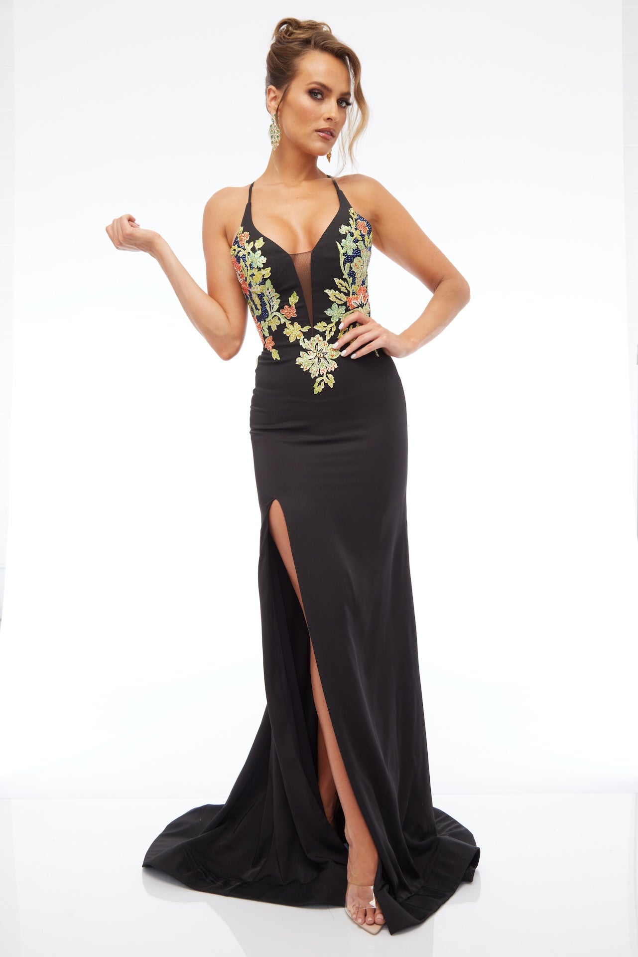 Front view of Style 7680: an enchanting black prom dress featuring detailed floral applique, high slit, lace up back, plunge neckline, and spaghetti straps.