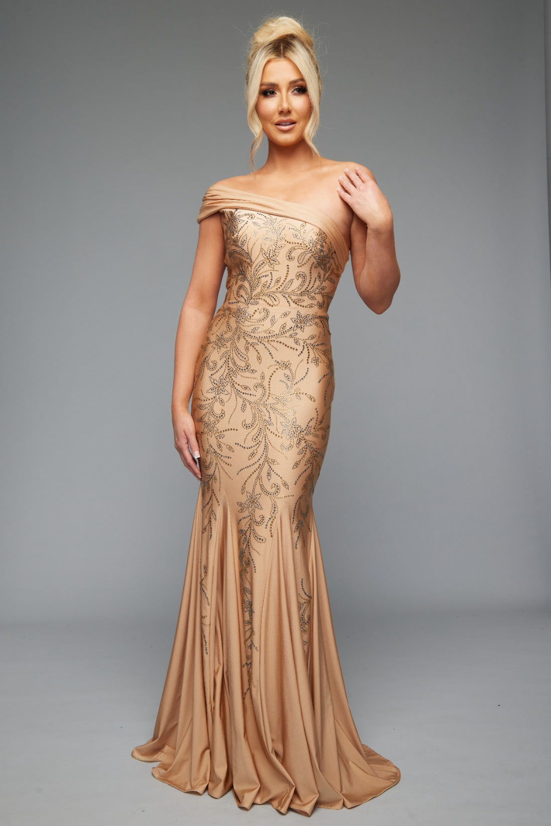 Front view of style 7621 prom dress with a beaded design, cut outs, and a unique one-shoulder off the shoulders neckline shown in NUDE, offering an elegant look.