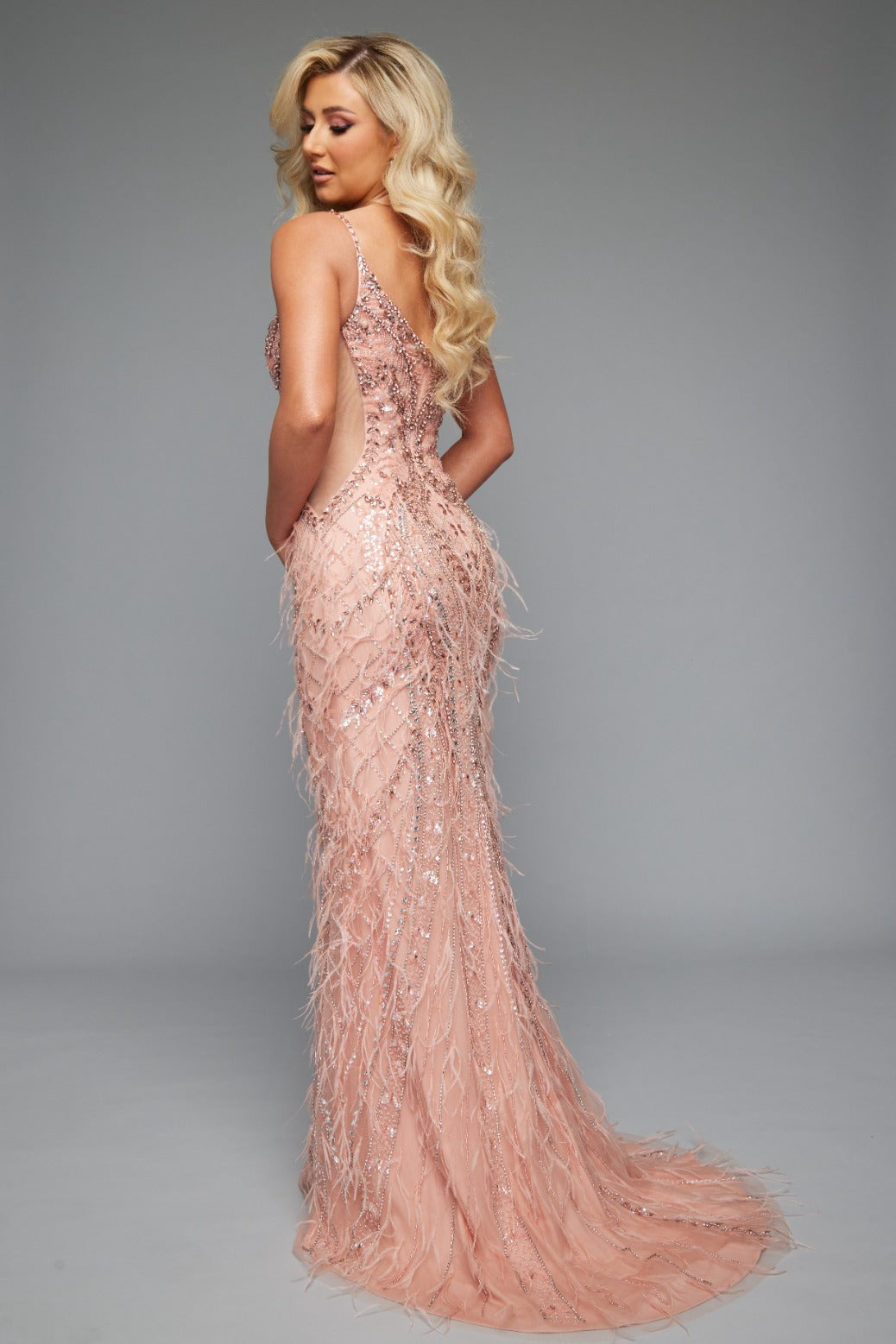 Back view of Style 7637: a long fitted spaghetti strap blush prom dress featuring a beaded fringe design with sheer side cutouts.