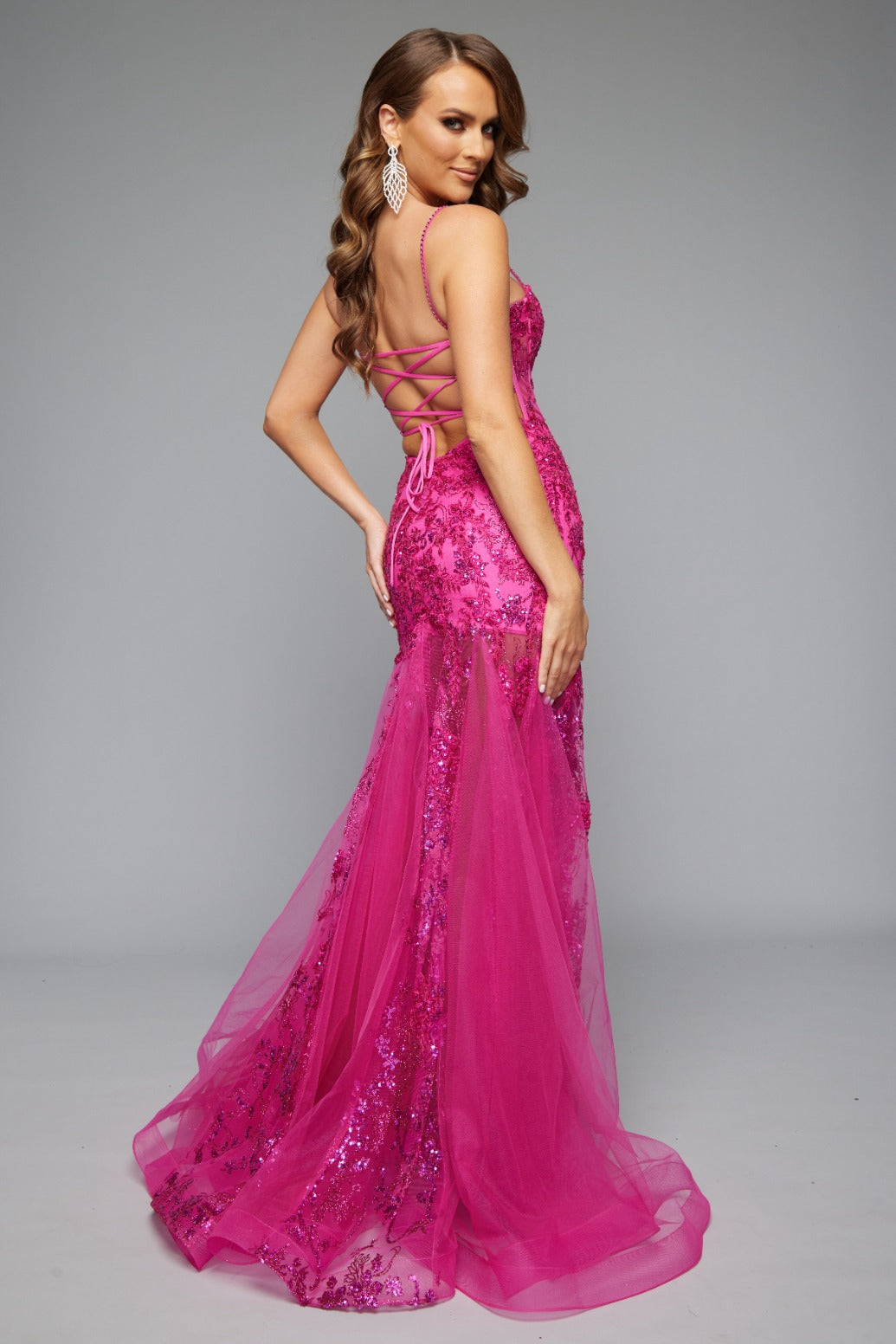 Back view of Jasz Couture Style 7652: an elegant best selling fuchsia beaded prom dress with a corset lace up detail and spaghetti straps.