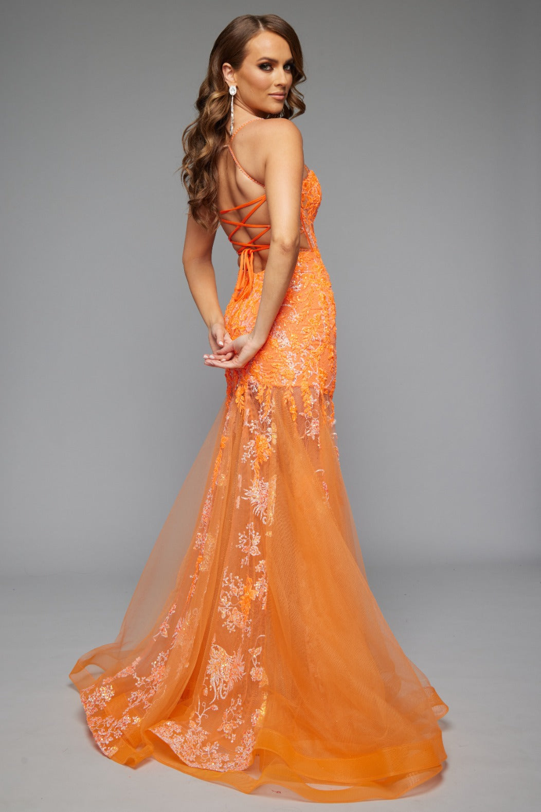 Back view of Jasz Couture Style 7652: an elegant best selling orange beaded prom dress with a corset lace up detail and spaghetti straps.