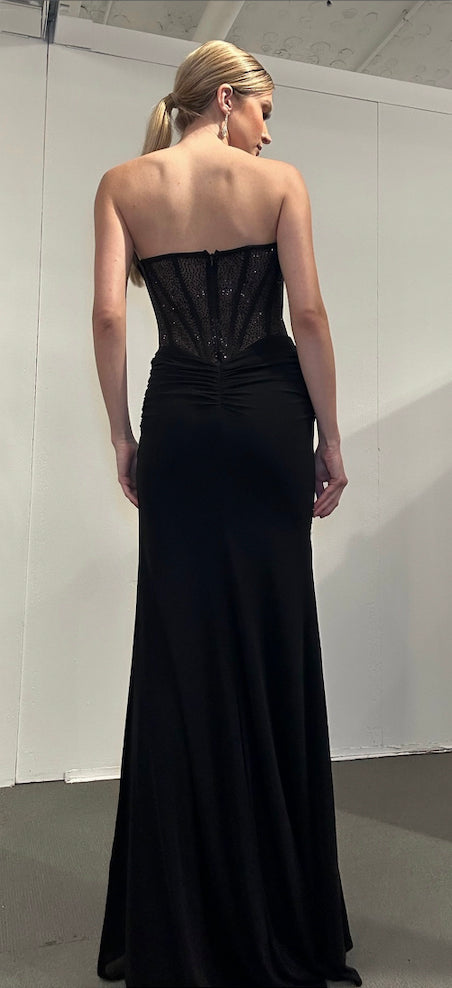 Back view of Jasz Couture Style 7710: a dazzling strapless black prom dress featuring a corset, cutouts, a high slit, and a sweetheart neckline.