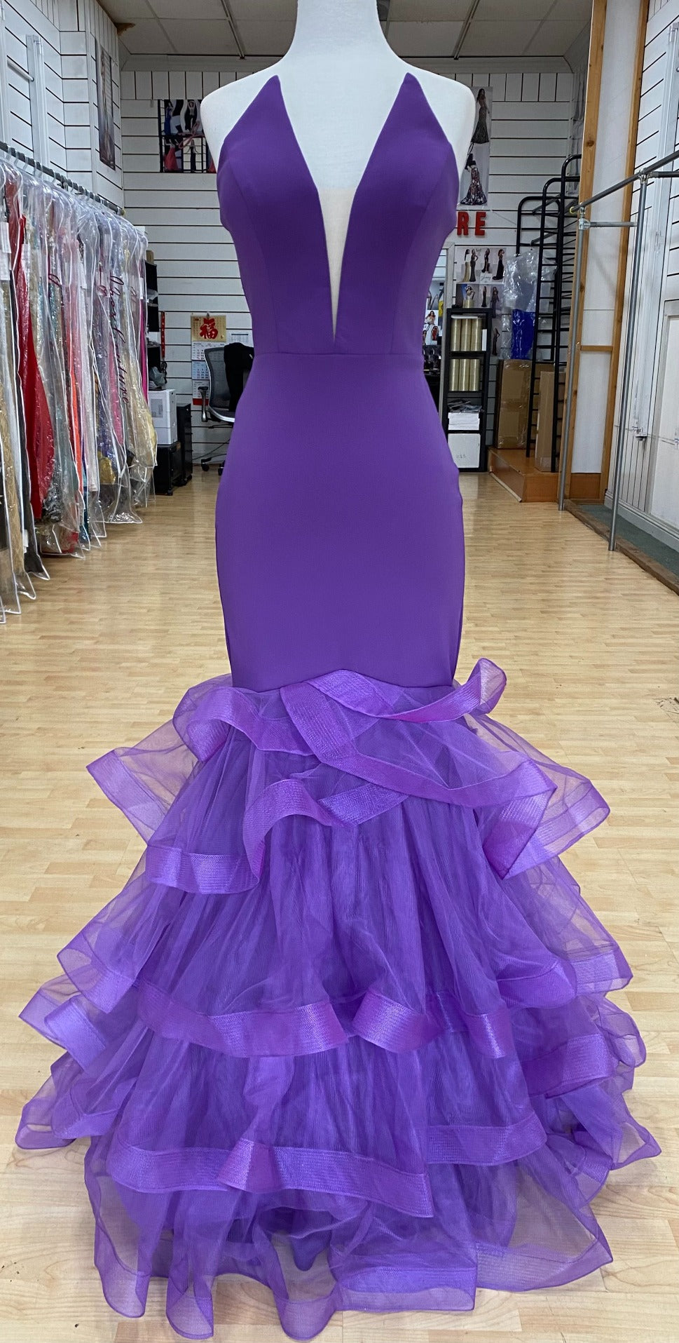 Front of Style 7670: a captivating fitted purple prom dress with a strapless plunge neckline and tulle skirt. 